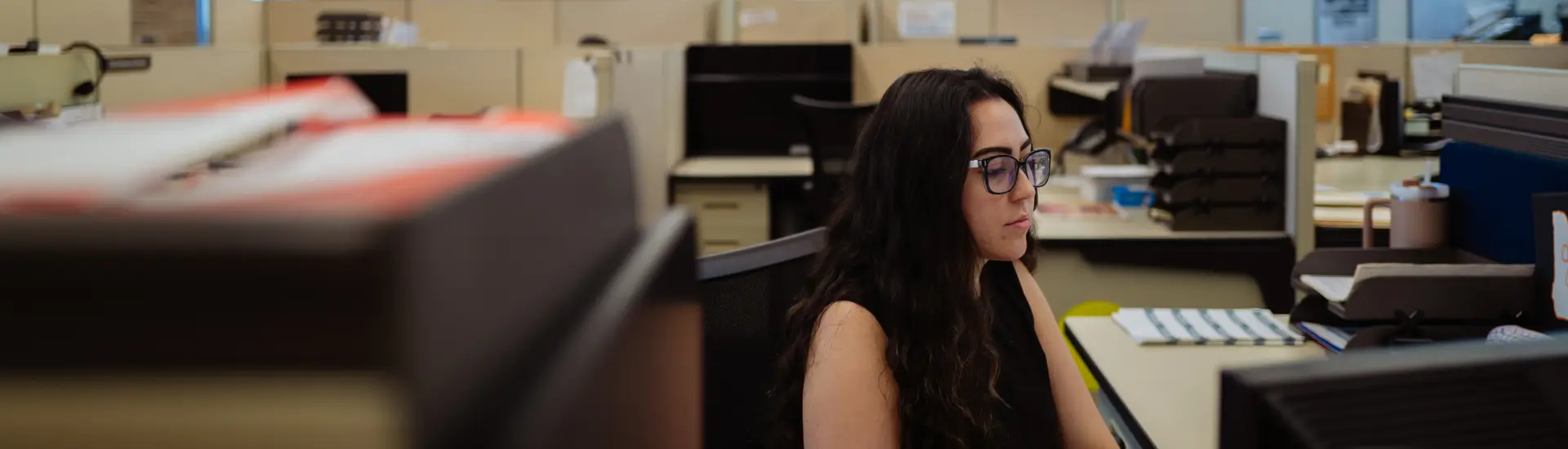 A graphic designer at The Columbian working at the computer