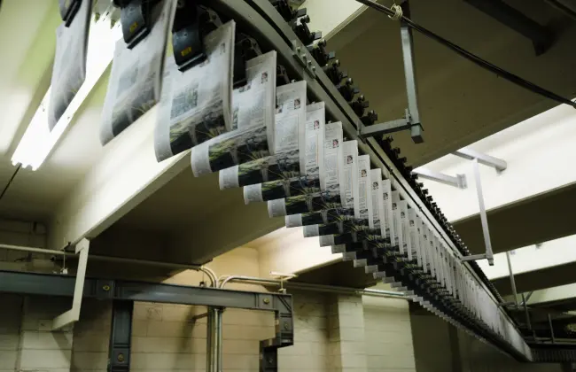 Freshly printed editions of The Columbian suspended on a conveyor